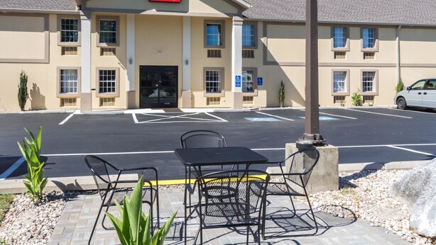 A hotel with a sign reading "EconoLodge," outdoor seating with tables and chairs, and a parking lot. - Econo Lodge Harrisburg - Southwest of Hershey Area (Harrisburg)