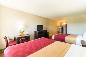 A hotel room with two beds, a desk with a chair, a television, a small refrigerator, and a potted plant. - Econo Lodge Harrisburg - Southwest of Hershey Area (Harrisburg)