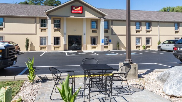 A hotel with a parking lot, outdoor seating, and a sign for EconoLodge.