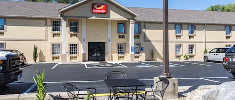 Un hotel con estacionamiento, mesas al aire libre y un letrero de EconoLodge.