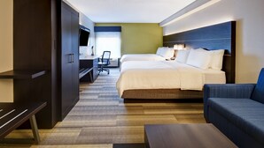 Une chambre d’hôtel avec un grand lit, un bureau avec une chaise, une télévision et un canapé.