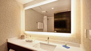 Une salle de bain moderne avec un grand miroir, deux lavabos et un porte-serviettes.