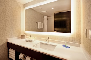 Une salle de bain moderne avec un grand miroir, deux lavabos et un porte-serviettes.
