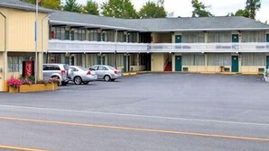 A motel with a two-story structure, a parking lot, and several cars parked in front. - Royal Inn Clearfield (Clearfield)