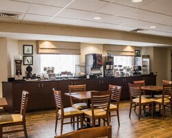 A hotel lobby with a reception desk, seating area, and a coffee station.