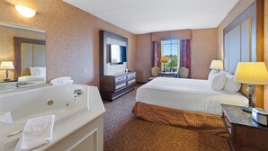 A hotel room with a large bed, a separate bathroom with a bathtub, a desk with a lamp, and a large mirror. - Heritage Hills Golf Resort (York)