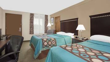 A hotel room with two beds, a desk, a chair, and a window with curtains.