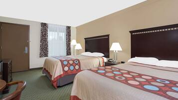 A hotel room with two beds, a desk, and a chair.
