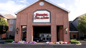 Un edificio de ladrillo con un letrero que dice "Hampton Inn & Suites".
