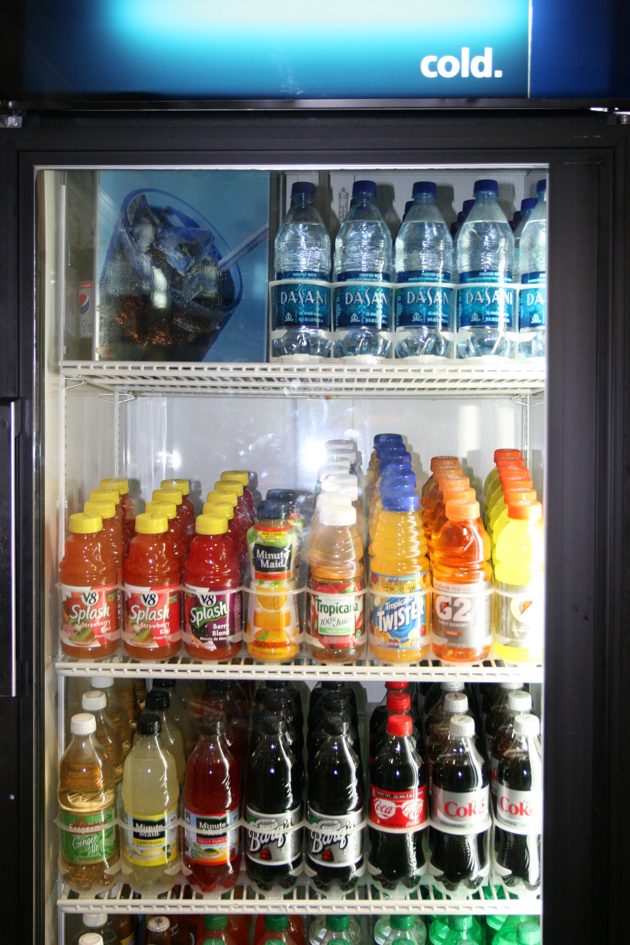 A beverage vending machine with multiple shelves stocked with various drinks.