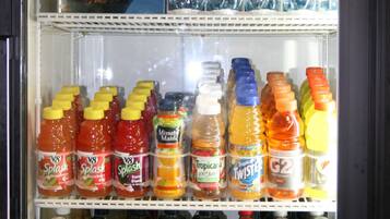 Máquina expendedora de bebidas con varios estantes llenos de diferentes opciones.