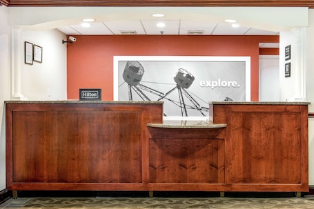 A hotel reception desk with a framed picture of a Ferris wheel and the word "explore."
