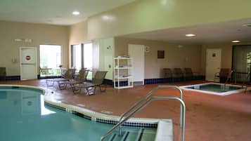 A pool area with lounge chairs, a small table, and a changing room.