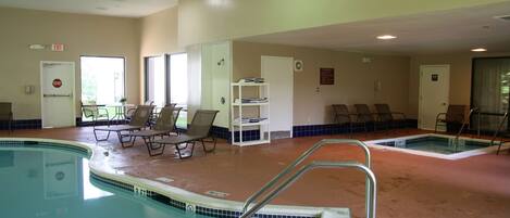 A pool area with lounge chairs, a small table, and a changing room.