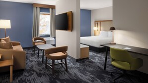 A hotel room with a bed, a desk, a chair, a sofa, and a TV. - Fairfield by Marriott Inn & Suites Columbia Lexington (Lexington)