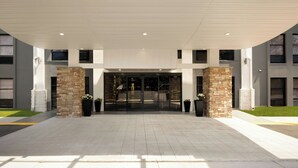 A modern building entrance with a flat roof, large glass doors, and a stone column. - Fairfield by Marriott Inn & Suites Columbia Lexington (Lexington)