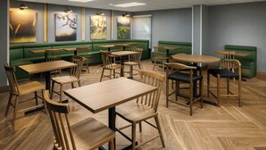 A restaurant with green booths, wooden tables, and chairs. - Fairfield by Marriott Inn & Suites Columbia Lexington (Lexington)