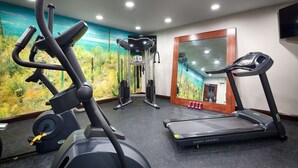 A gym with a treadmill, elliptical, and weight machine, featuring a large mirror and a mural on the wall. - Best Western Plus Hardeeville Inn & Suites (Hardeeville)