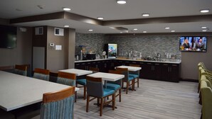 A modern restaurant with a bar area, multiple seating options including booths and tables, and a television screen displaying a news program. - Best Western Plus Hardeeville Inn & Suites (Hardeeville)