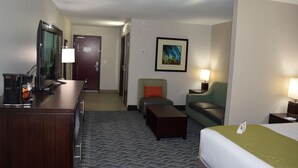 A hotel room with a bed, a desk with a lamp, a chair, a sofa, a coffee machine, and a painting on the wall. - Best Western Plus Hardeeville Inn & Suites (Hardeeville)