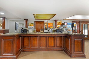 A large wooden kitchen island with a built-in coffee station, a microwave, and a refrigerator. - Comfort Suites Sumter near Shaw AFB (Sumter)