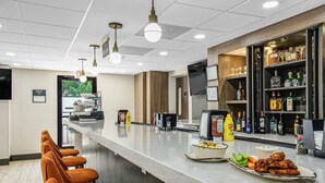 Un espace bar doté d’un long comptoir, de tabourets de bar et d’une variété de bouteilles et de verres.
