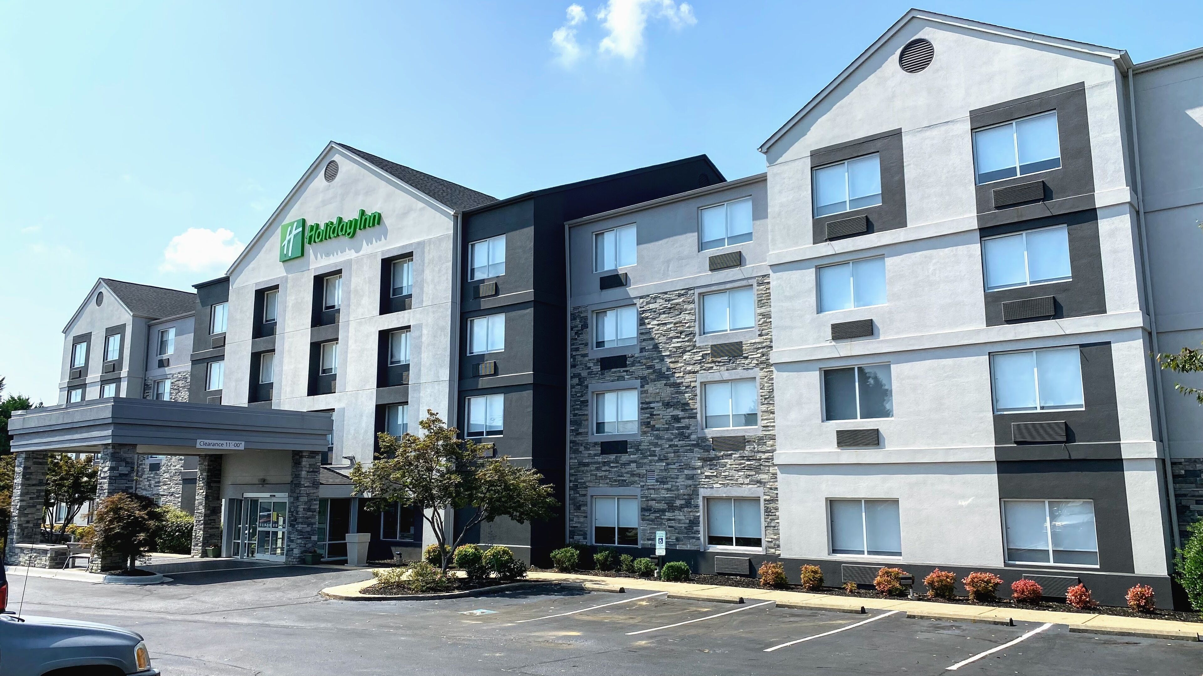 A Holiday Inn hotel with a modern design, featuring a stone facade and multiple balconies.