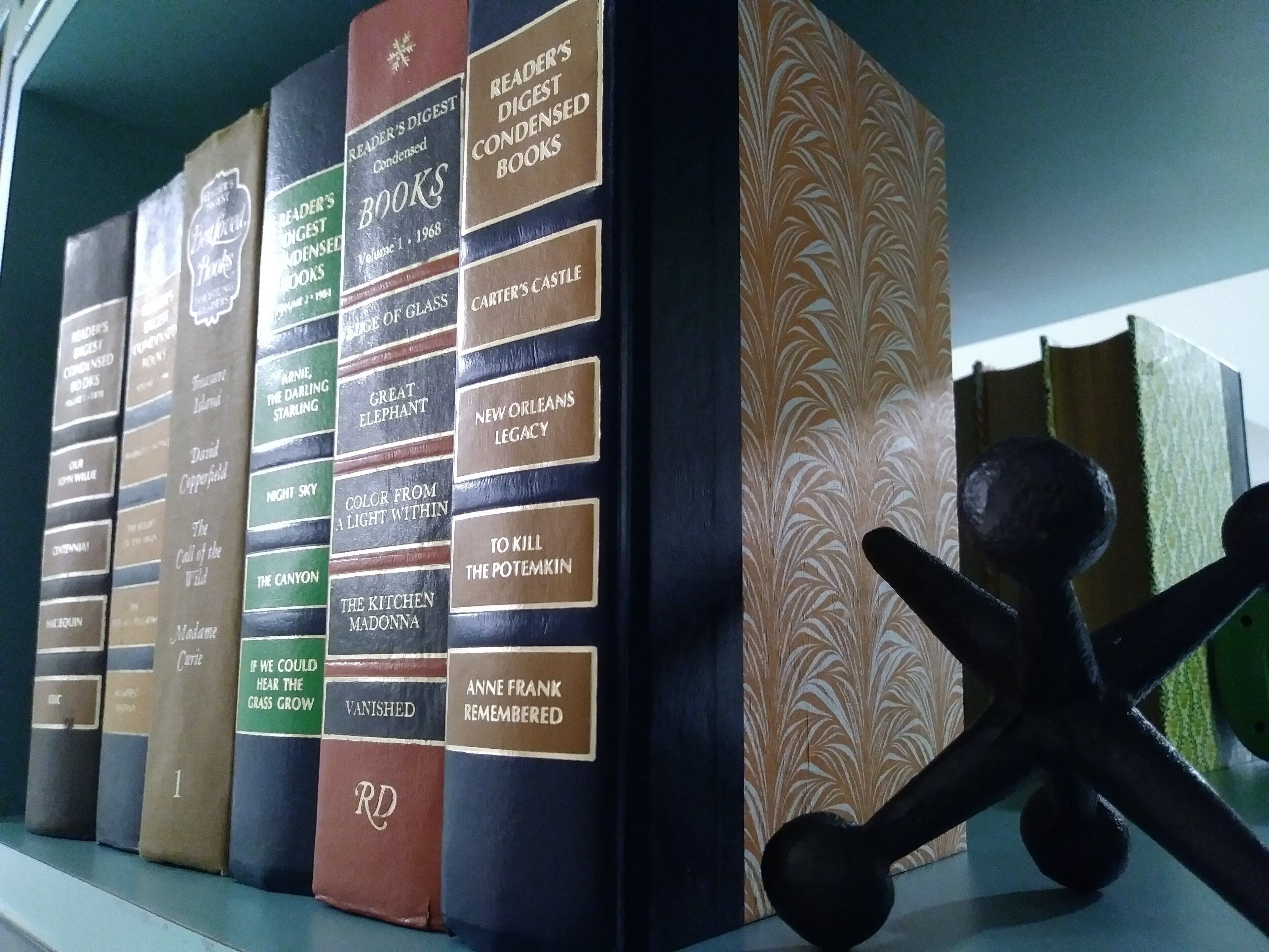 A collection of books on a shelf, including titles like 'Reader's Digest Condensed Books' and 'Great Elephant'.