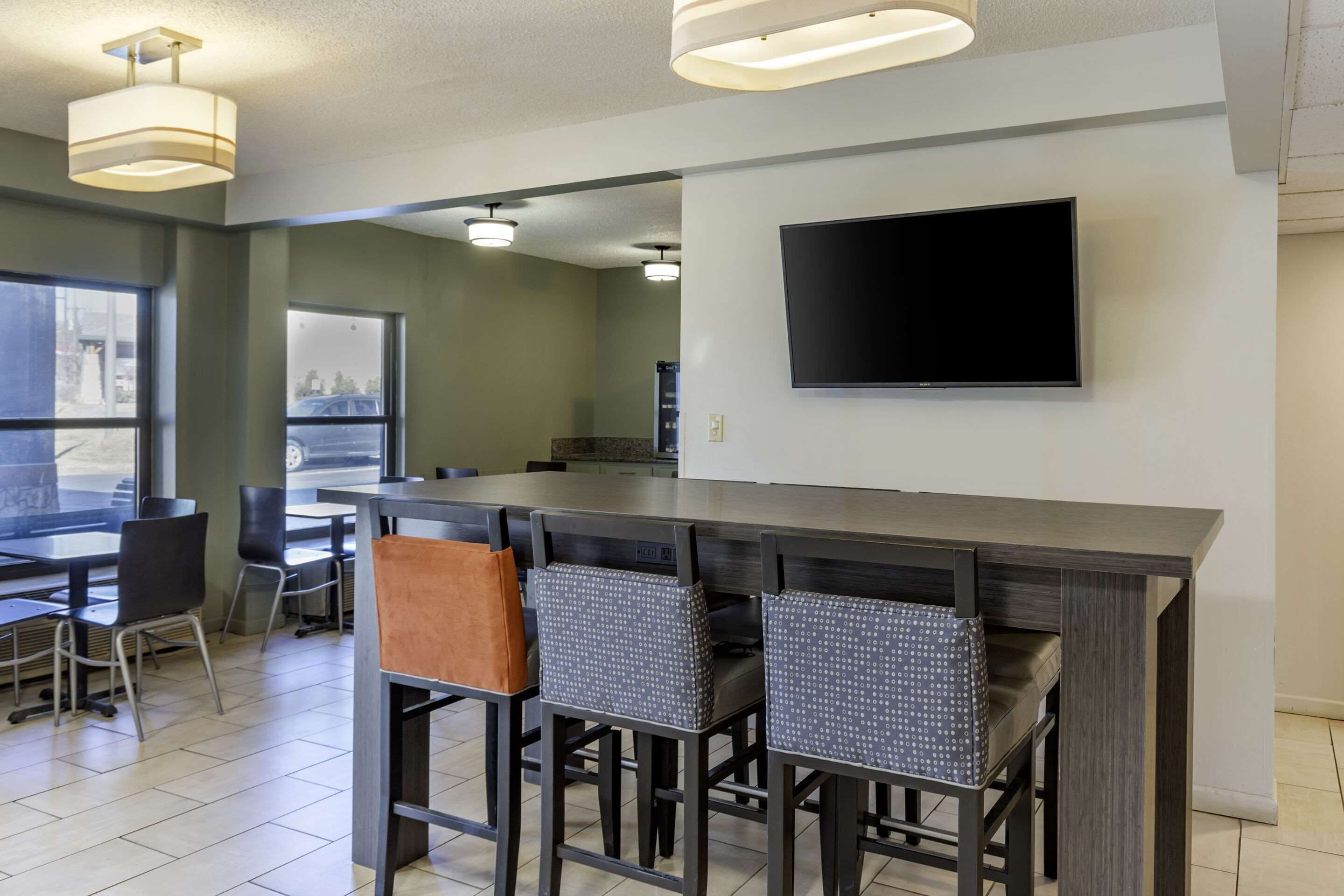 Una cocina moderna con una isla grande, taburetes de bar y un televisor de pantalla plana montado en la pared.