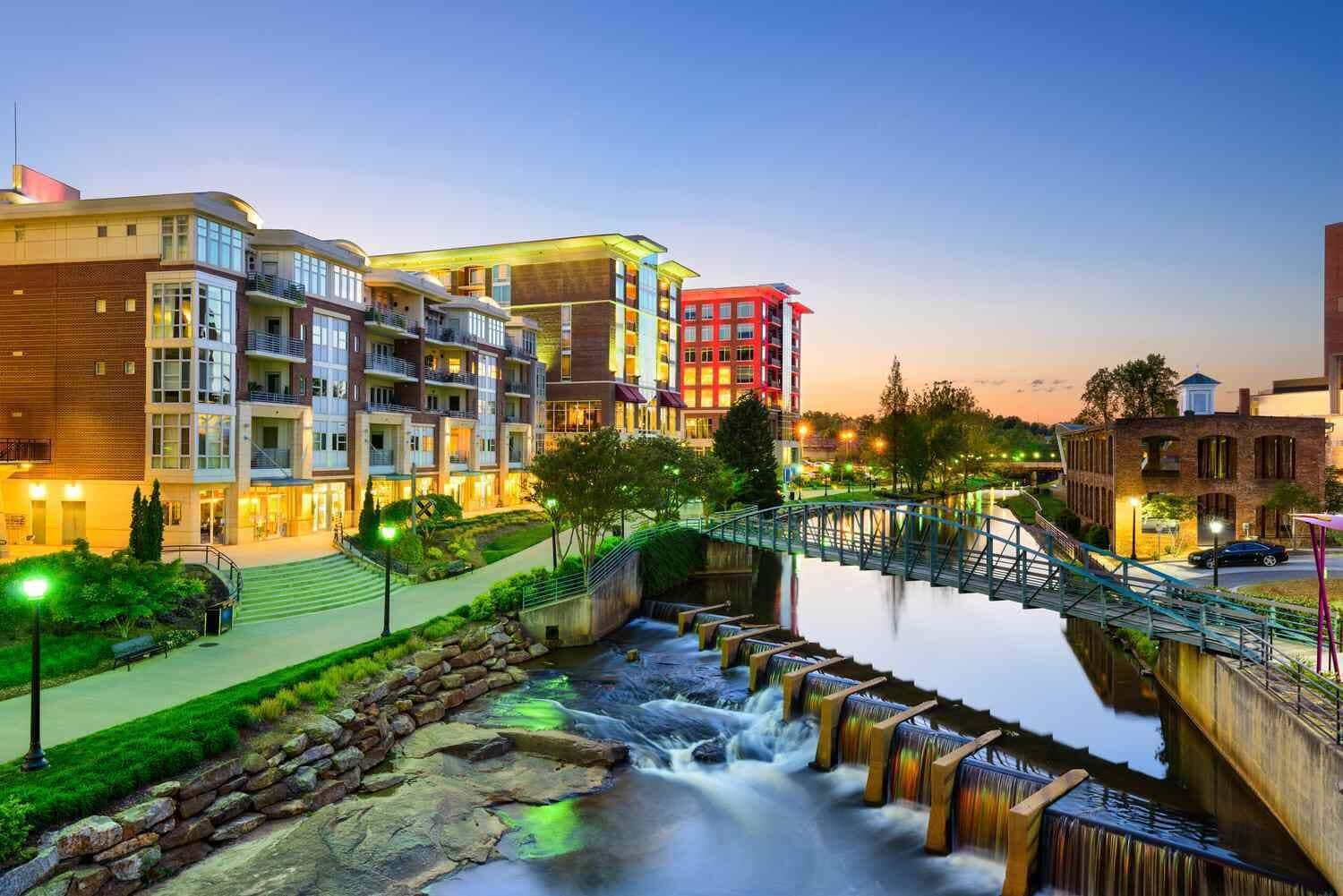 A modern hotel with multiple floors, a landscaped garden, and a waterfall feature.