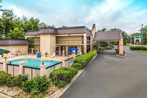 A hotel with a swimming pool, outdoor seating, and a covered entrance. - Quality Inn Walterboro I-95 (Walterboro)