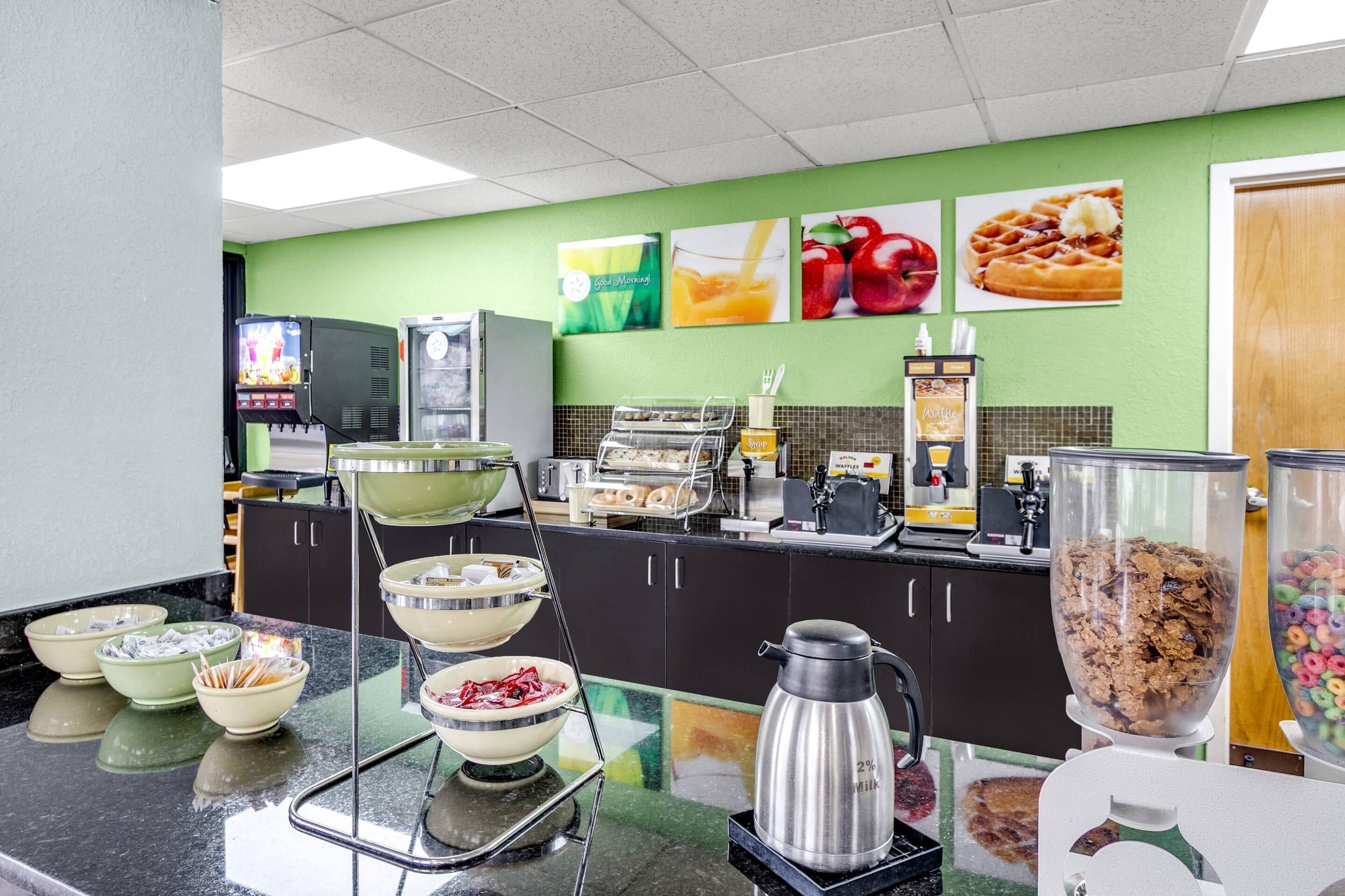 Ein Frühstücksbuffet mit Schüsseln voller Getreidefrühstück, einer Kaffeemaschine und einem Saftspender.