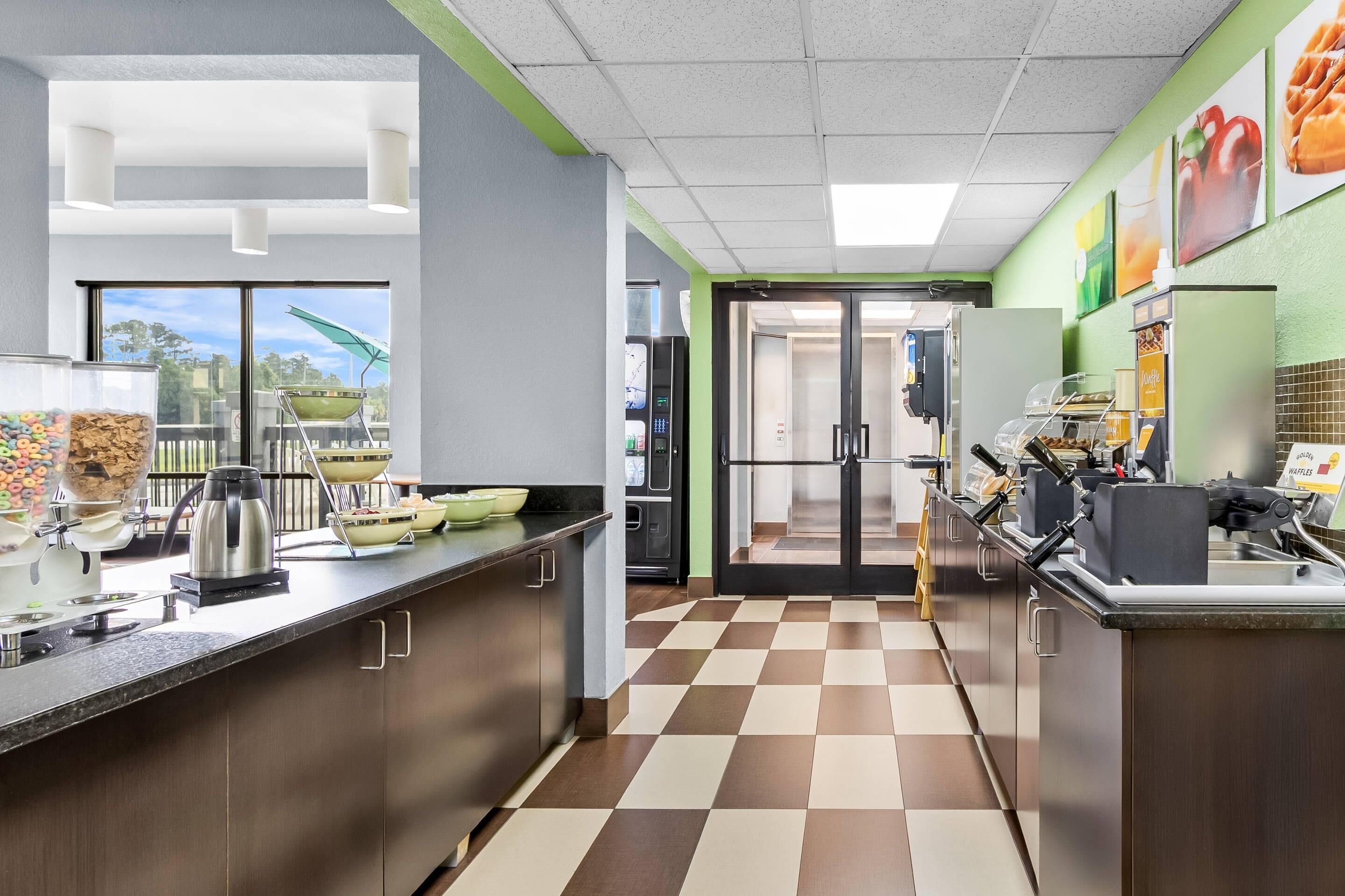 A modern kitchen with a checkered floor, a coffee machine, and a waffle station.