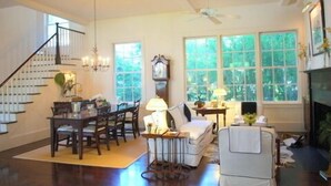 A spacious living room with a staircase, dining area, and a fireplace. - Rhett House Inn (Beaufort)