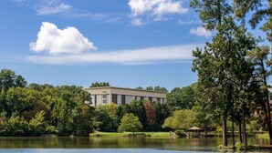 Un bâtiment entouré d’arbres et bordé par un lac.