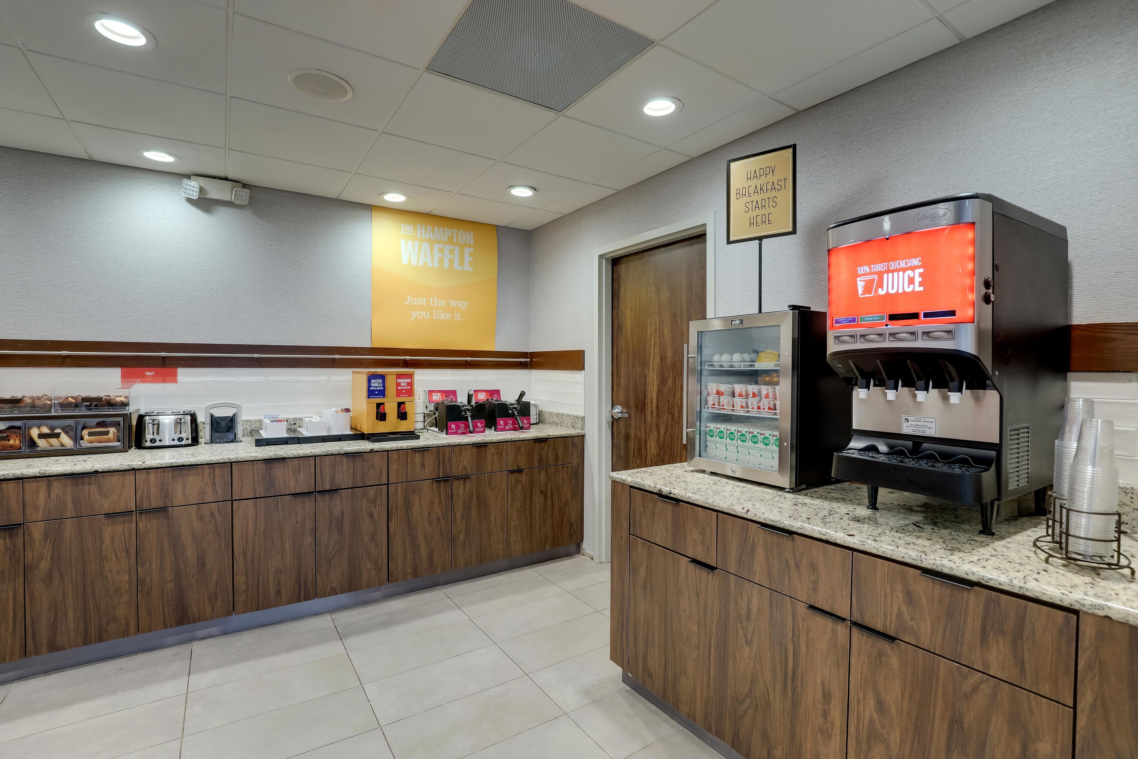 Un espace dédié au petit-déjeuner avec un appareil à gaufres, un distributeur de jus et un grille-pain.