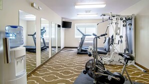 A fitness center with cardio machines, weightlifting equipment, and a water dispenser. - Quality Inn Huron (Huron)