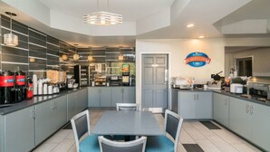 A modern kitchen with grey cabinets, a central island, and a breakfast bar. - Baymont by Wyndham Franklin/Cool Springs (Franklin)