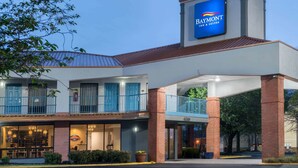 A Baymont Inn & Suites with a prominent blue sign, a brick facade, and a balcony overlooking the parking area. - Baymont by Wyndham Franklin/Cool Springs (Franklin)
