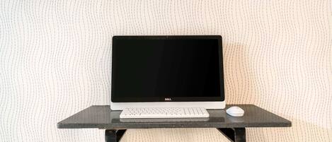 A Dell laptop on a black stand with a keyboard and mouse.