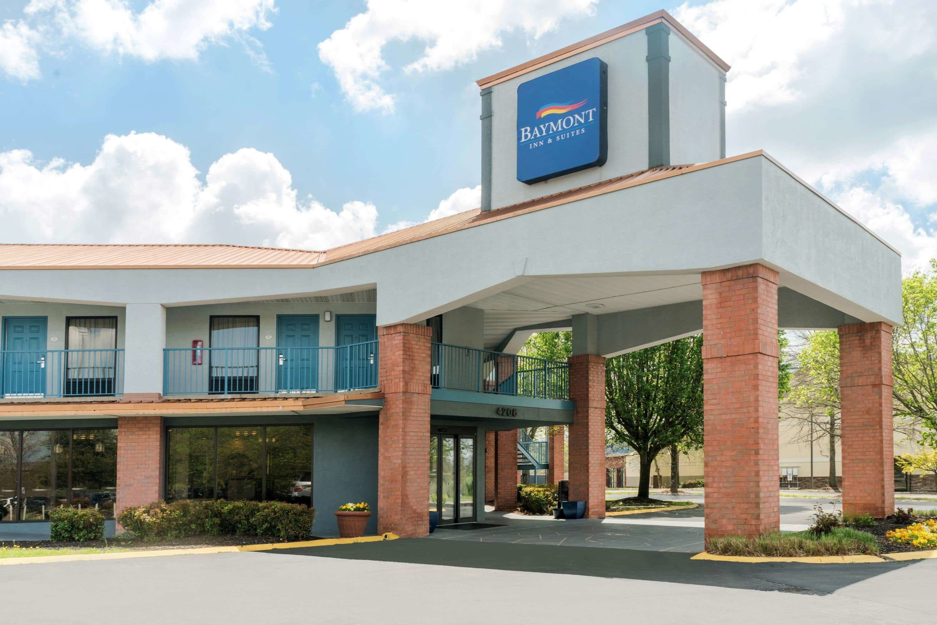 A Baymont Inn & Suites building with a flat roof, brick pillars, and a covered entrance.