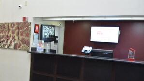 A reception desk with a digital screen displaying a message, a security camera, and a water dispenser.