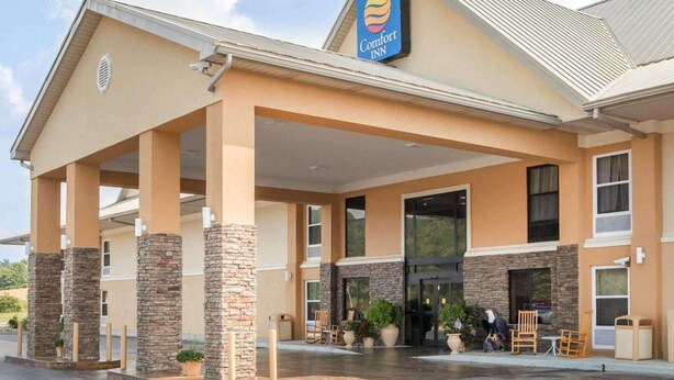 A Comfort Inn hotel with a covered outdoor area, stone pillars, and a clear sky.