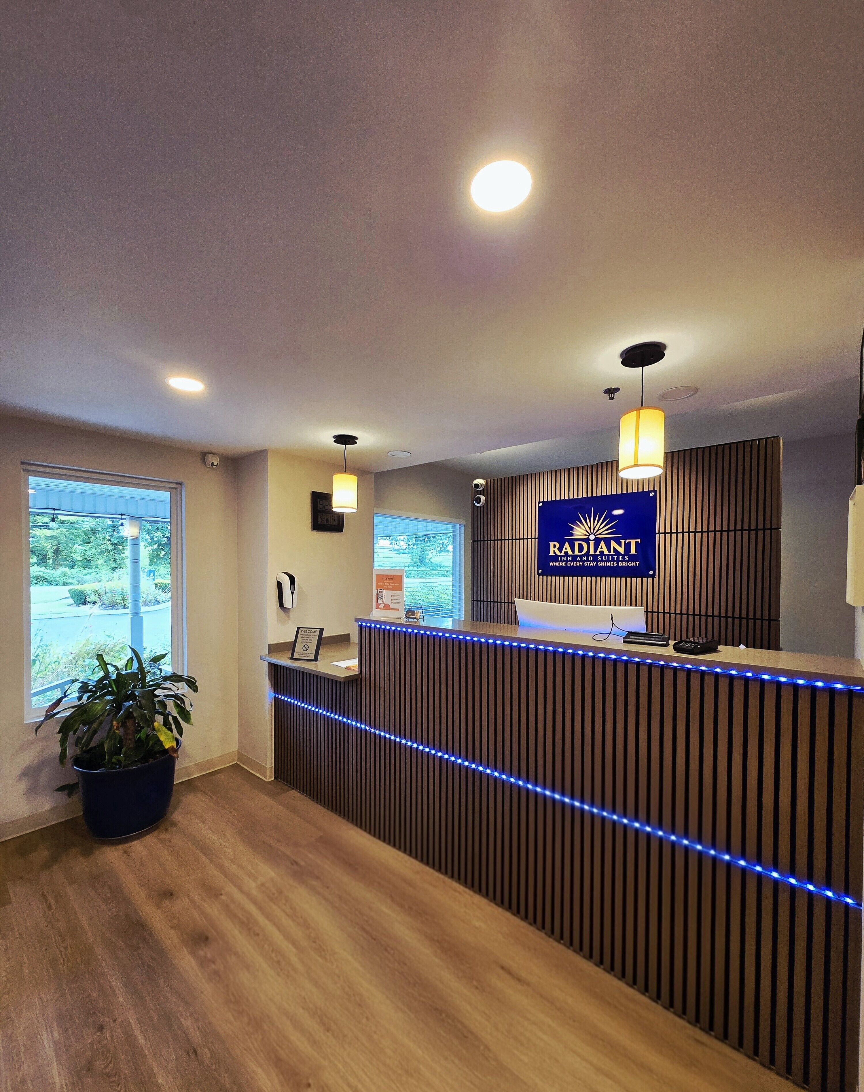 A reception desk with a blue sign, wooden paneling, and blue LED lights.
