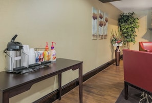 A reception area with a coffee station, a red chair, and a potted plant. - Red Roof Inn & Suites Knoxville East (Knoxville)