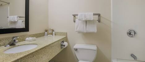 A bathroom with two sinks, a toilet, a shower, and a towel rack.