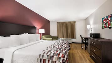 Une chambre d’hôtel avec un grand lit, un bureau, une chaise, une commode et un téléviseur.