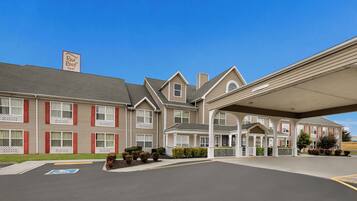 A Red Roof Inn with a covered parking area and a clear blue sky.
