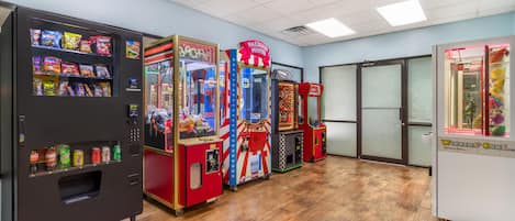 Eine Reihe von Spielautomaten und Verkaufsautomaten in einem Raum mit Holzboden und Fliesen Decke.