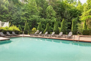 Una piscina techada, una piscina al aire libre, sombrillas